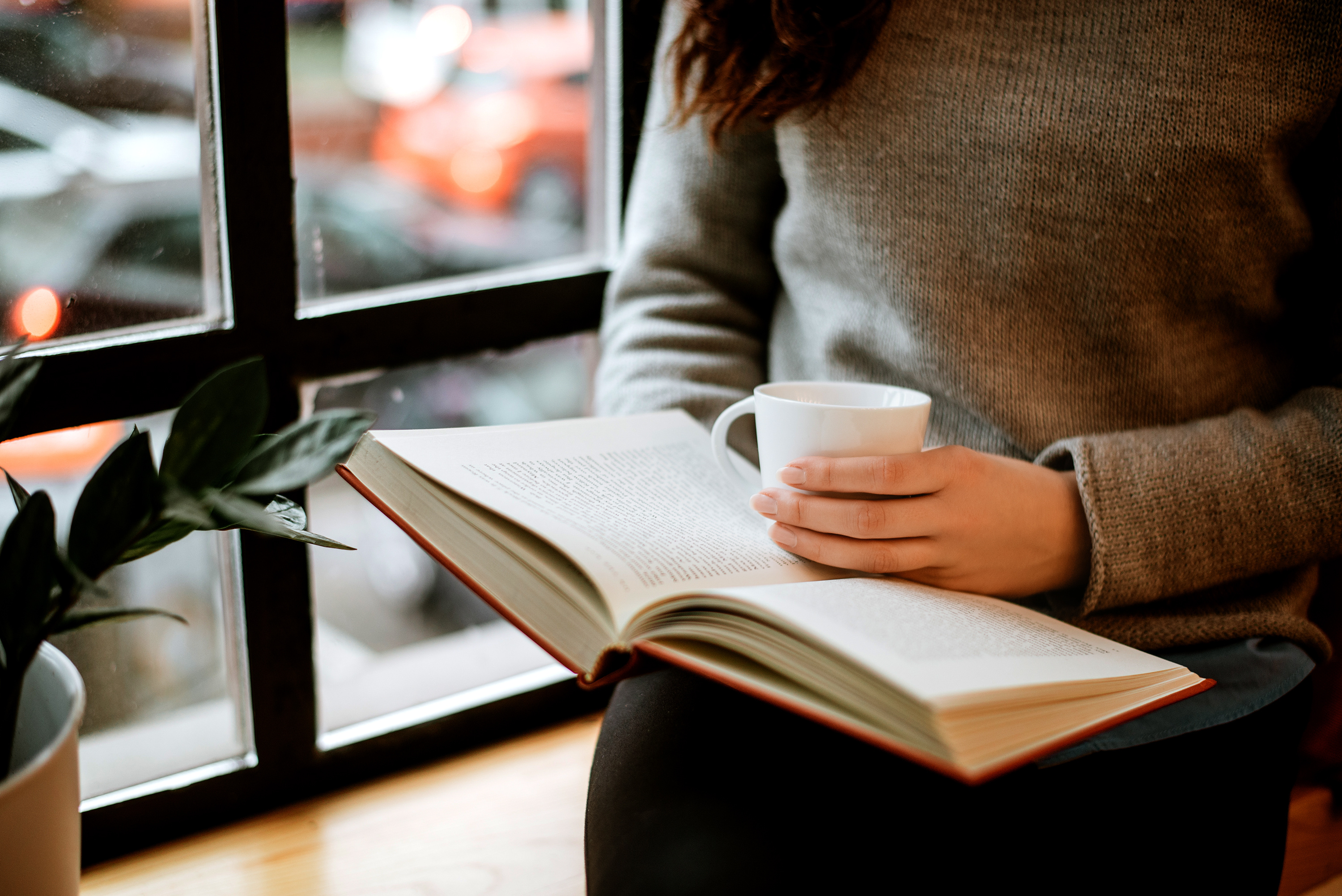 Woman reading a book with coffee