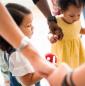 Toddlers holding hands with parents