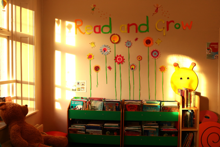 The children's shelves in the sunlight, On the wall there are decorations that say &quot;Read and and Grow&quot;